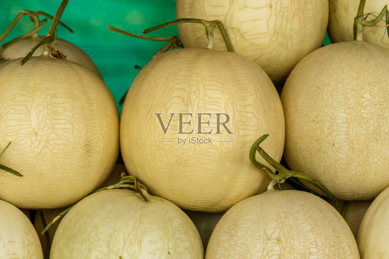 堆在桌子上出售的哈密瓜照片摄影图片