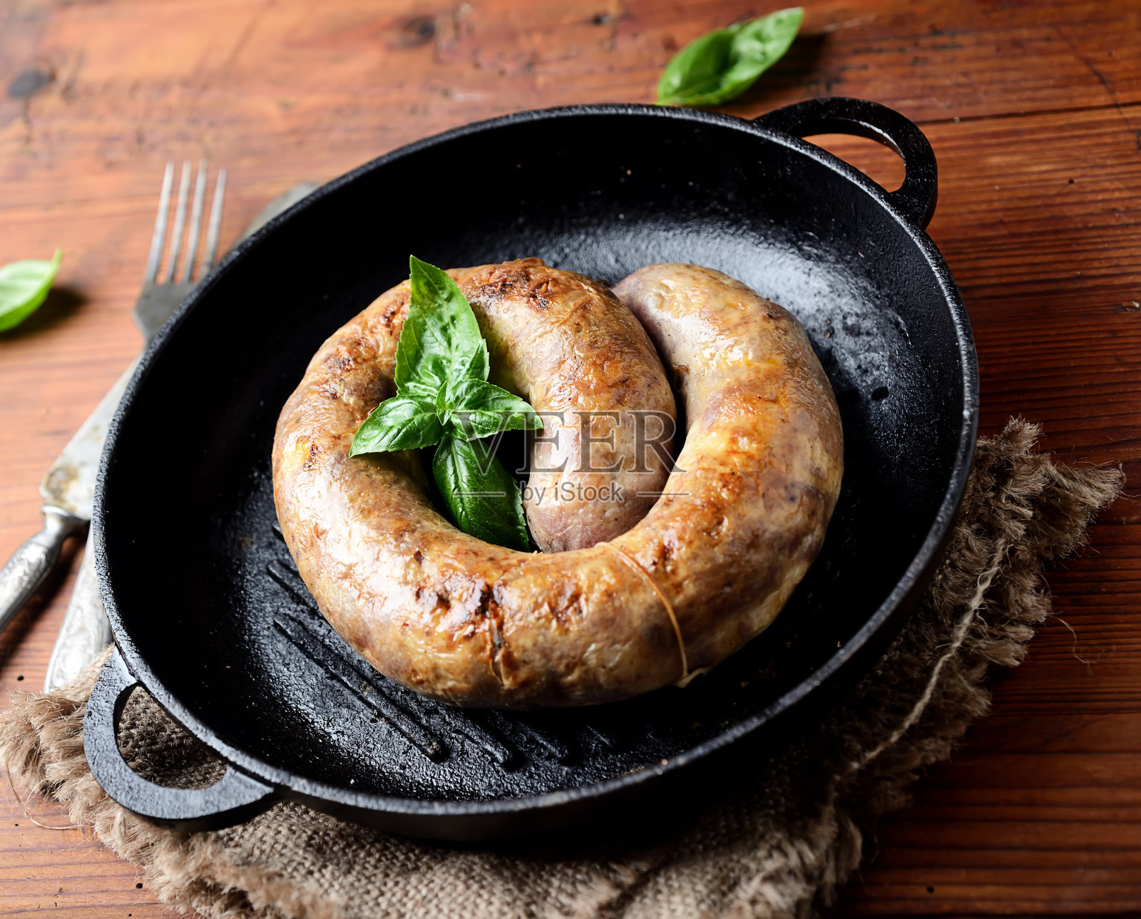 用平底锅自制香肠,背景是木头照片摄影图片