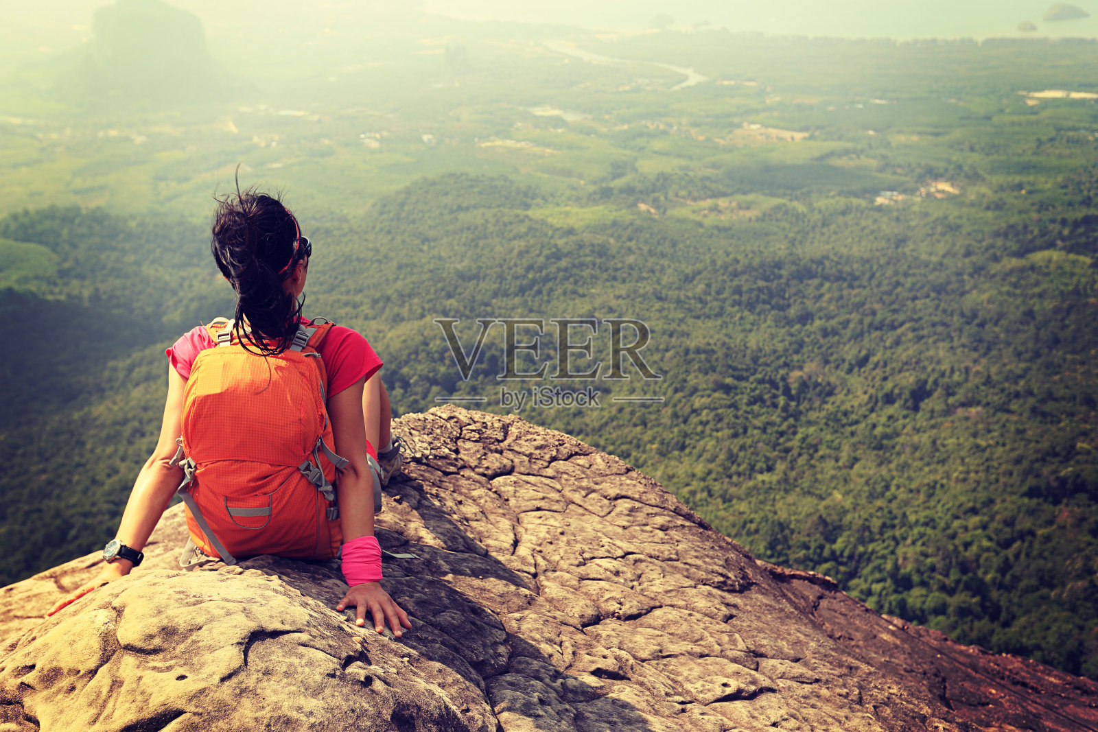 成功的女徒步旅行者欣赏山顶岩石的景色照片摄影图片