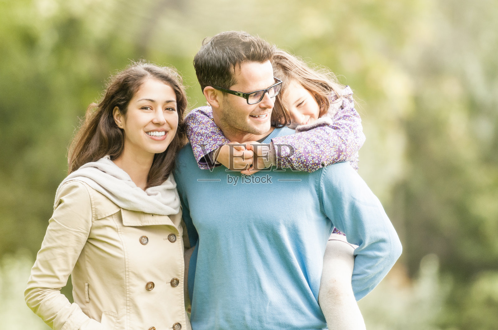 快乐的三口之家在户外玩。照片摄影图片