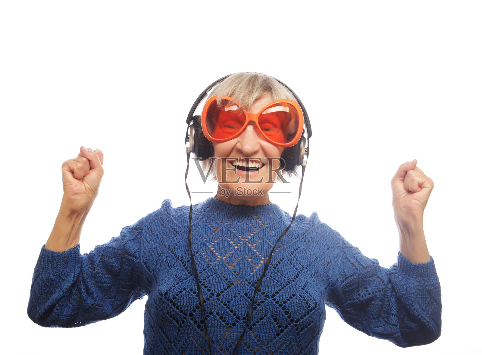 有趣的老女人一边听音乐一边竖起大拇指。照片摄影图片