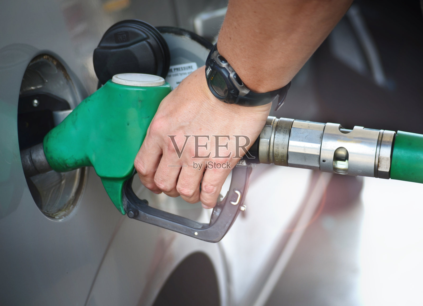 往油箱里加油的人。照片摄影图片