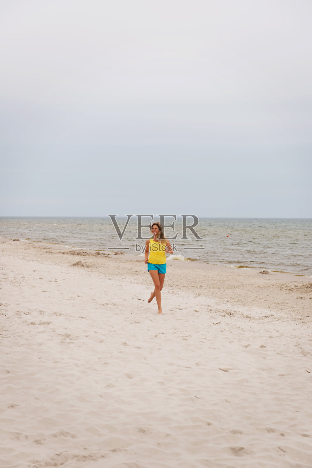 年轻女子在沙滩上跑步照片摄影图片