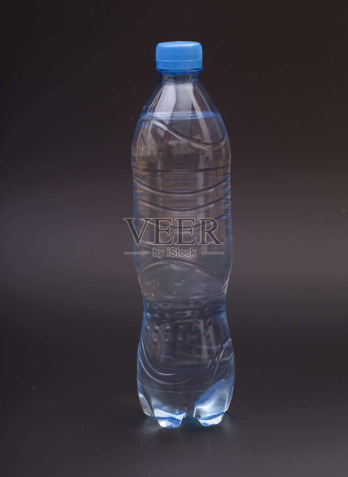 黑色背景上的小塑料水瓶照片摄影图片