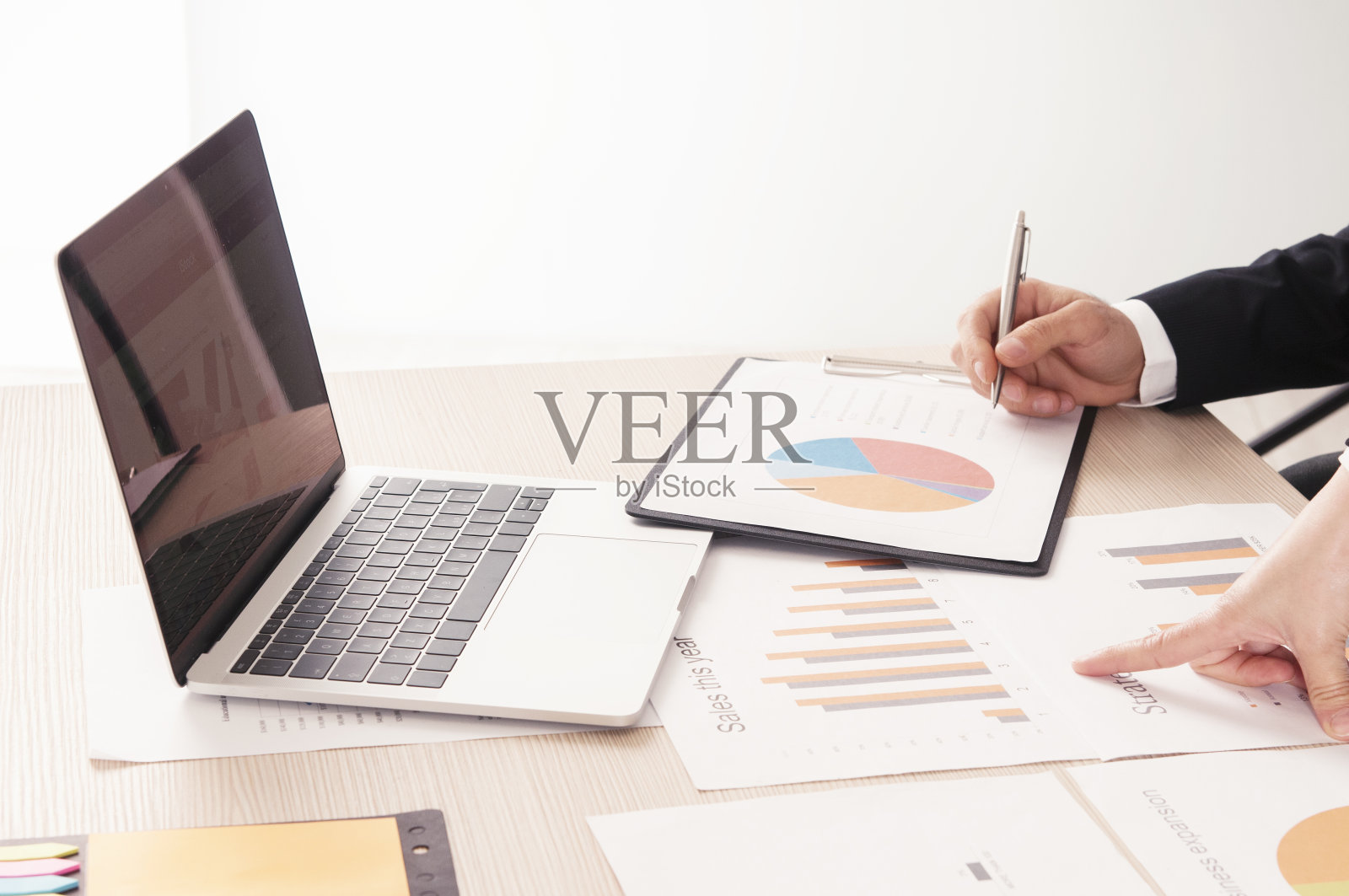 在办公桌上的商业图表和商人用笔记本电脑照片摄影图片