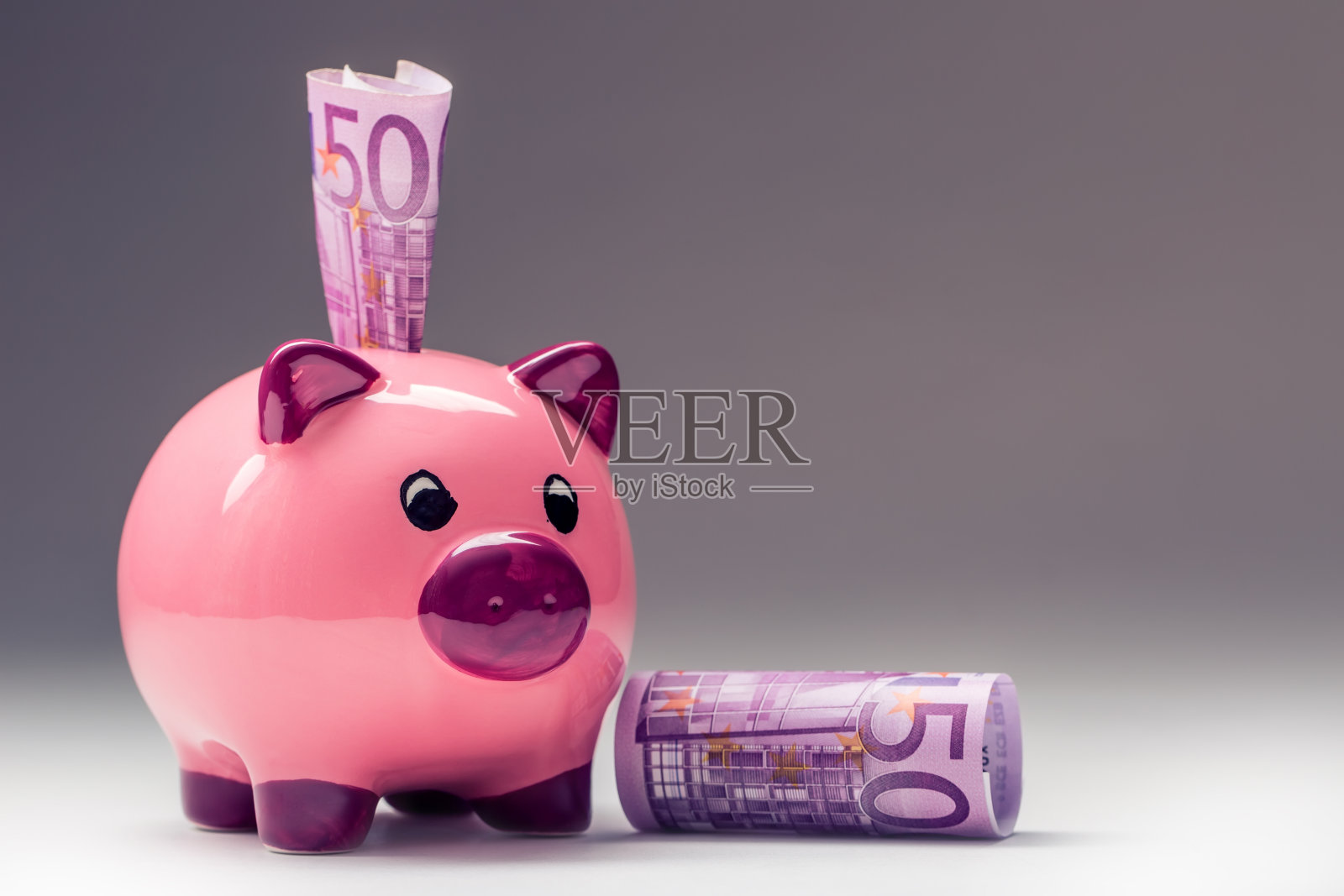扑满。粉红小猪储蓄和500欧元钞票。照片摄影图片