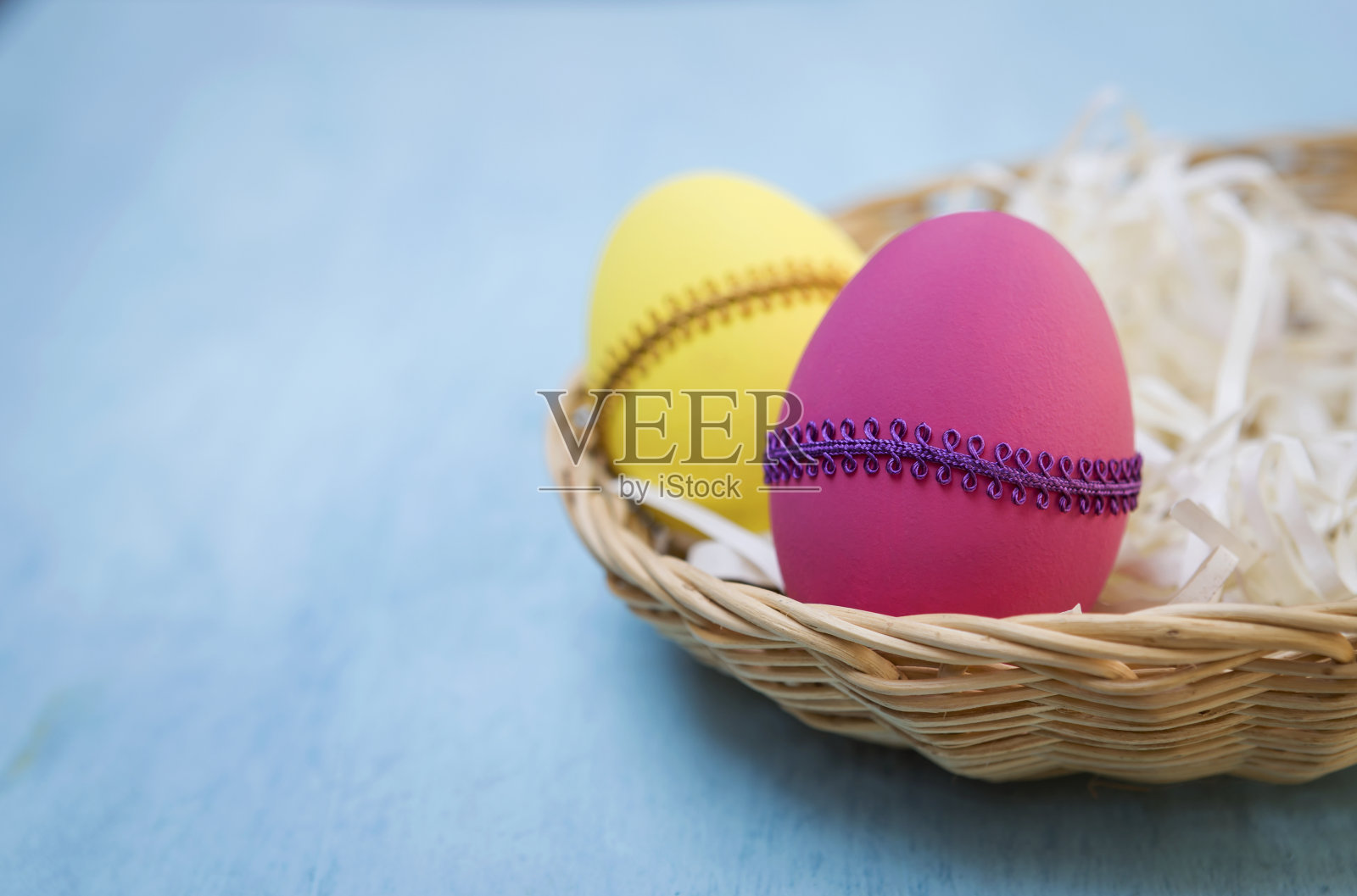 在藤篮子里设计复活节彩蛋照片摄影图片