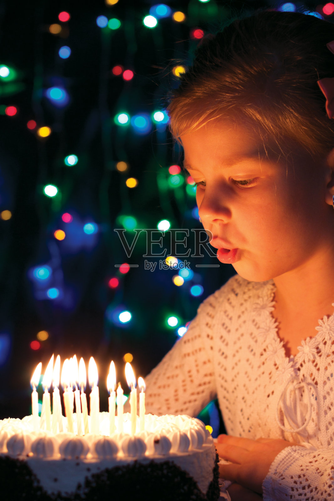 女孩吹灭蛋糕上的蜡烛照片摄影图片