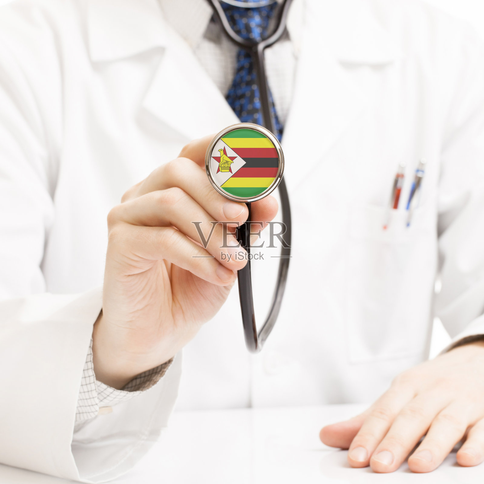 医生手持带有旗帜图案的听诊器——津巴布韦照片摄影图片