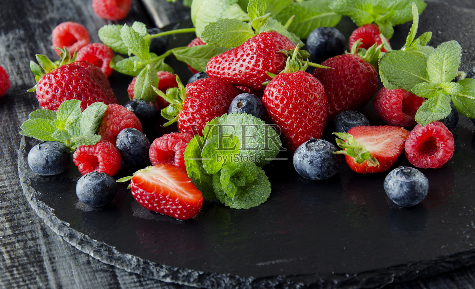 新鲜的草莓,树莓和蓝莓在黑色的背景照片摄影图片