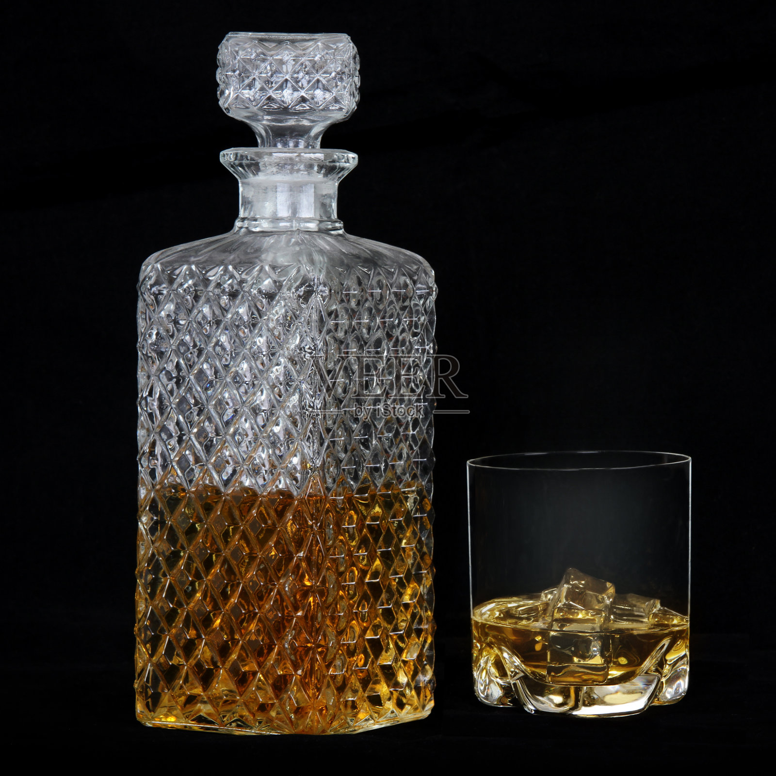 一杯加冰的威士忌和一个方形醒酒器照片摄影图片