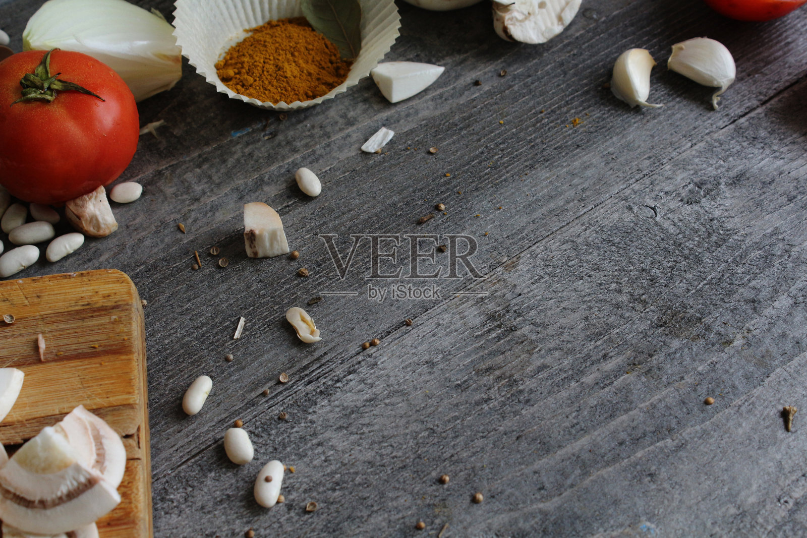 灰色的木桌上放着蔬菜,洋葱,蘑菇,辣椒,芦笋和香料。烹饪的过程。概念的食物。烹饪。照片摄影图片