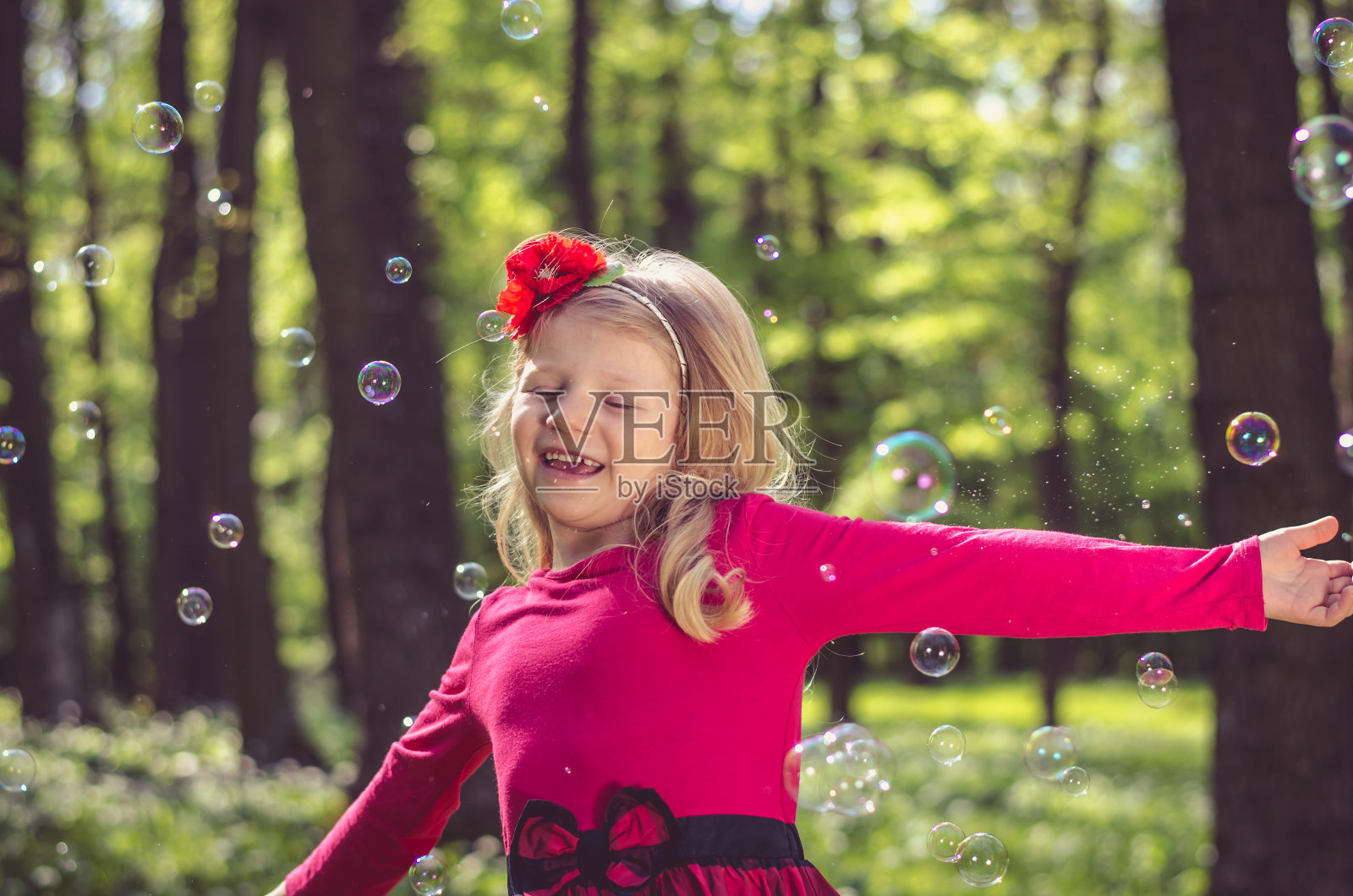 可爱的金发女孩在玩肥皂泡照片摄影图片