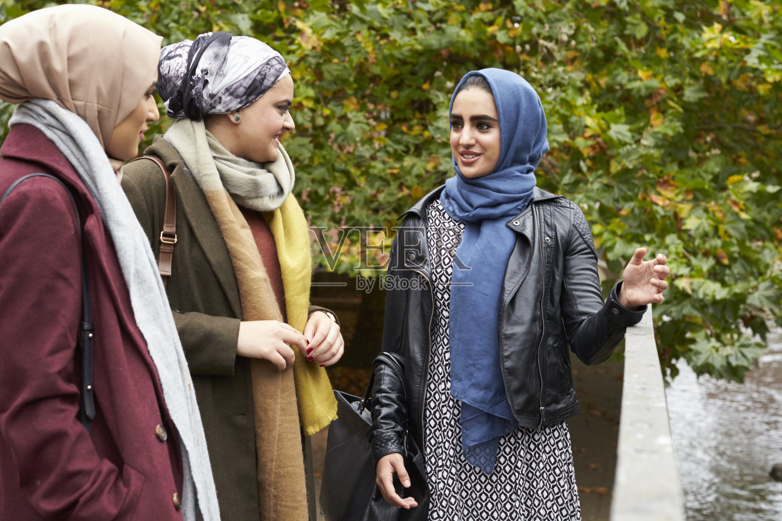 在城市环境中见面的英国穆斯林女性朋友照片摄影图片