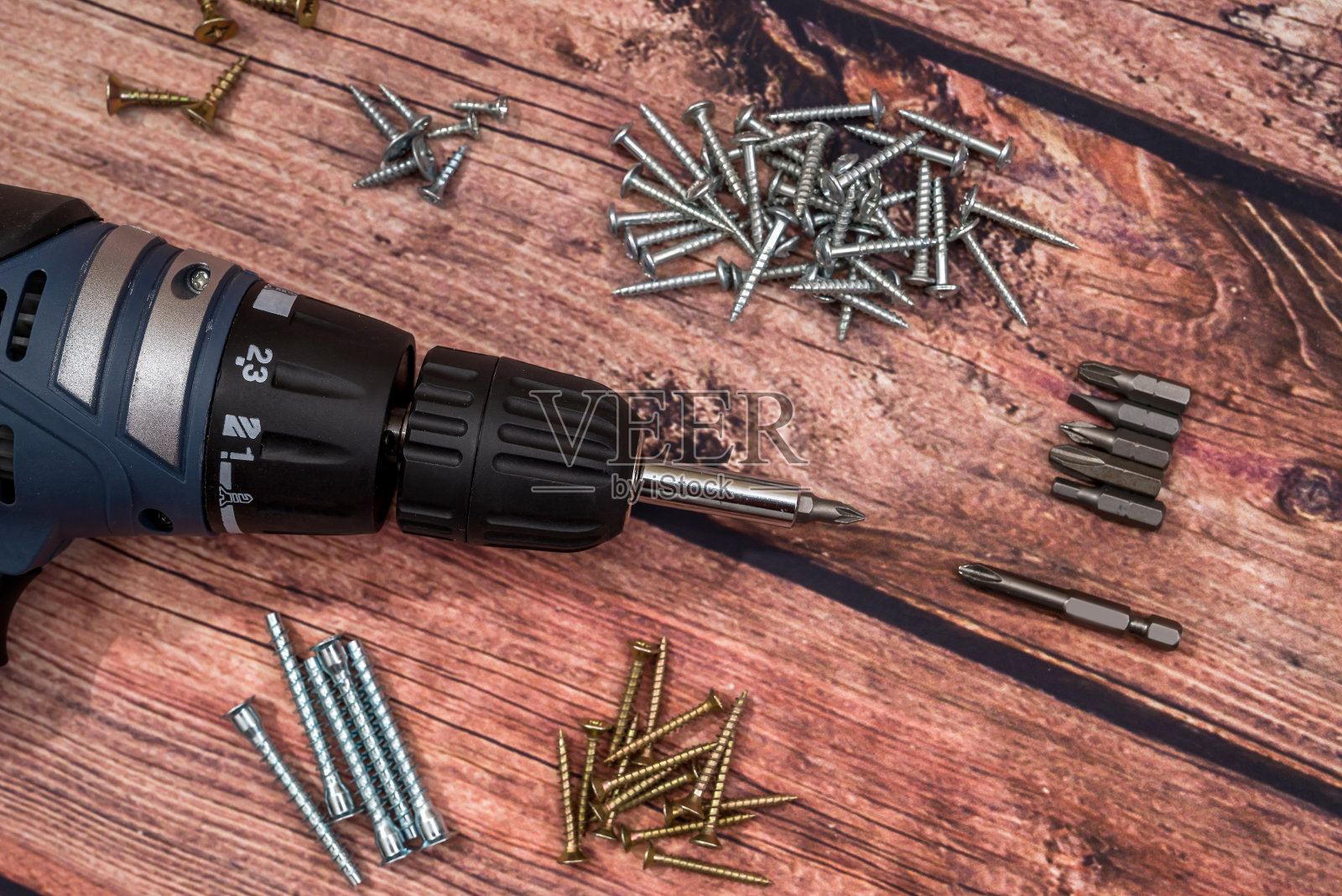 木桌上的螺丝刀、钻头和螺丝照片摄影图片