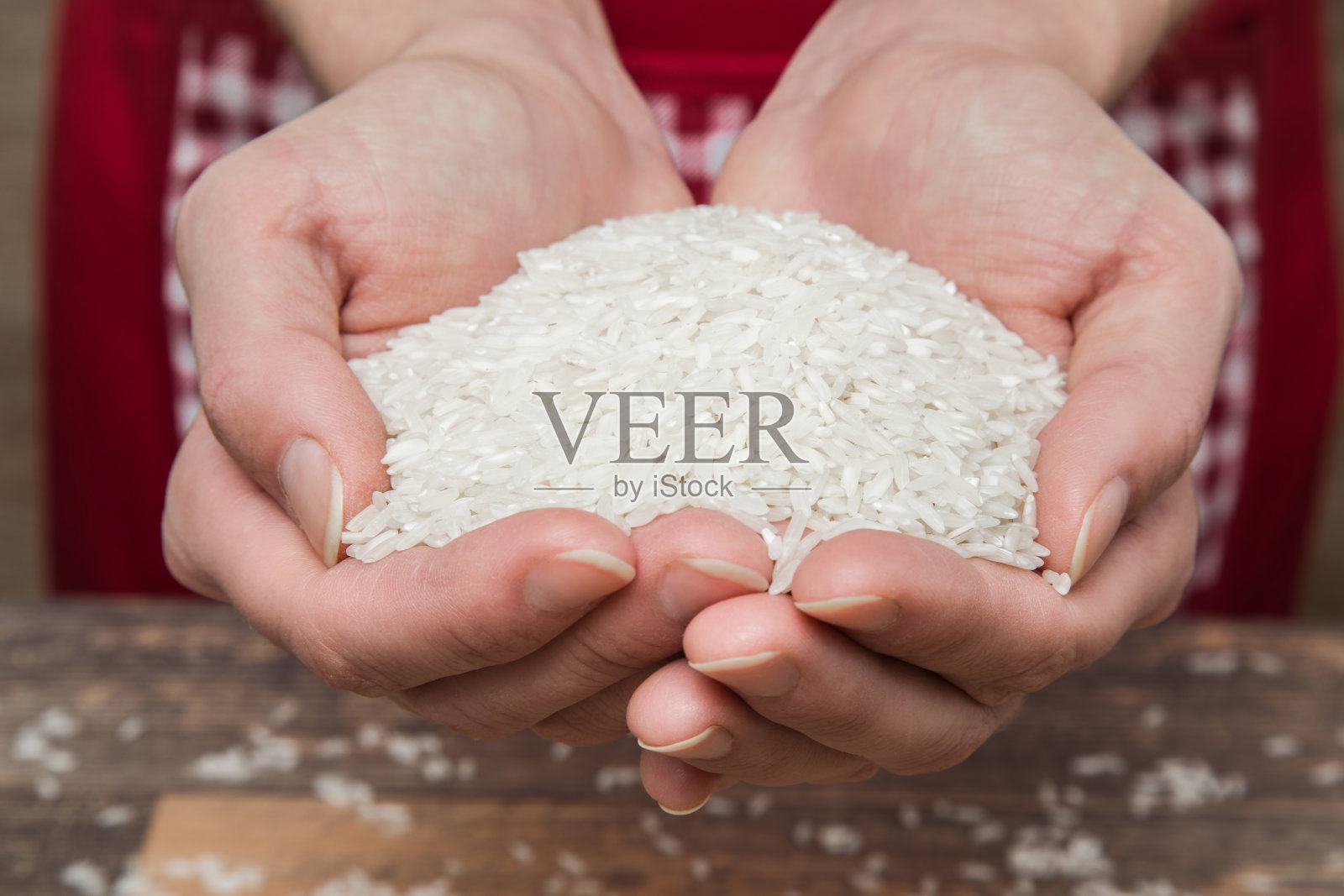 木桌上,手里拿着米饭。健康饮食。照片摄影图片