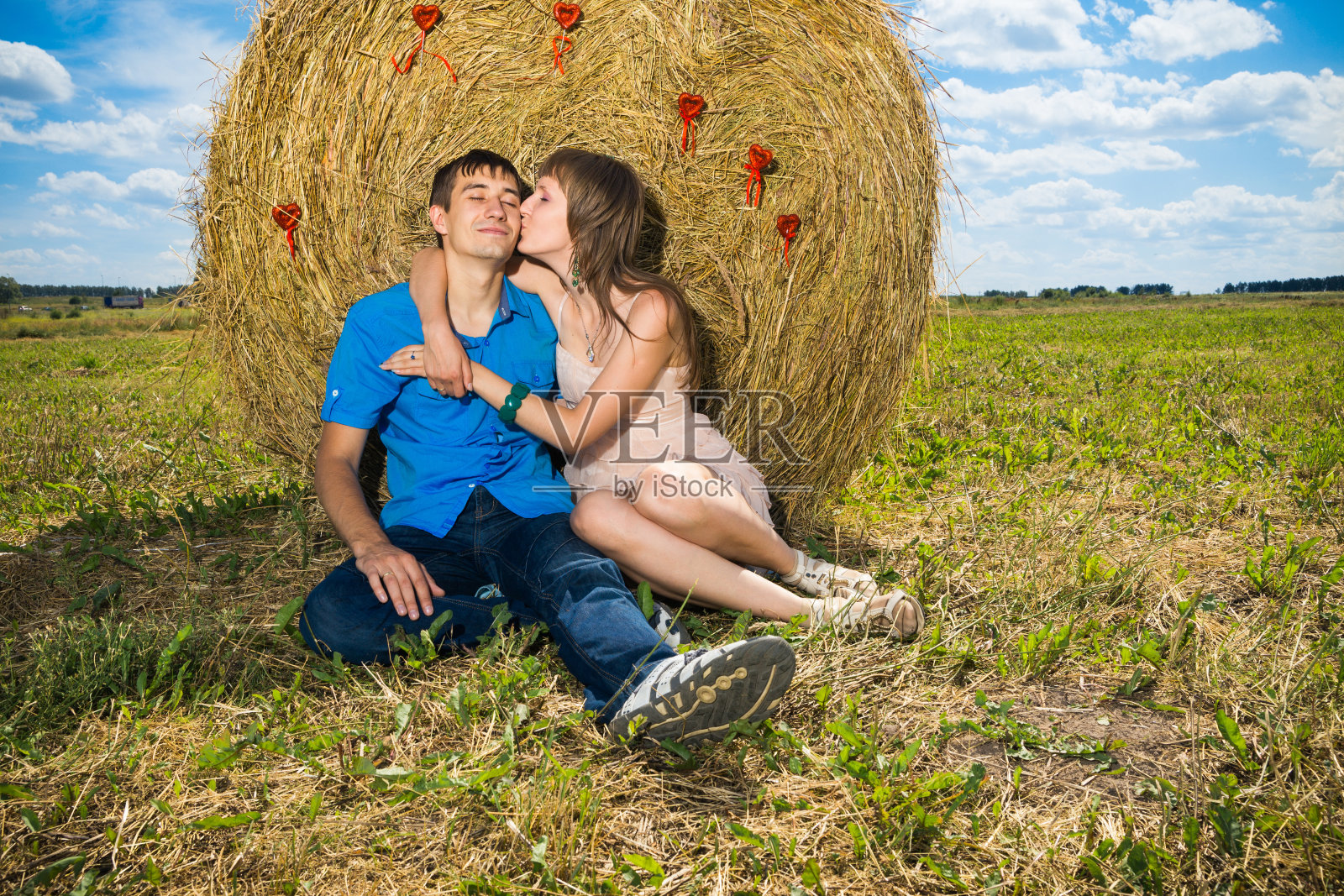 年轻情侣在干草堆附近接吻照片摄影图片