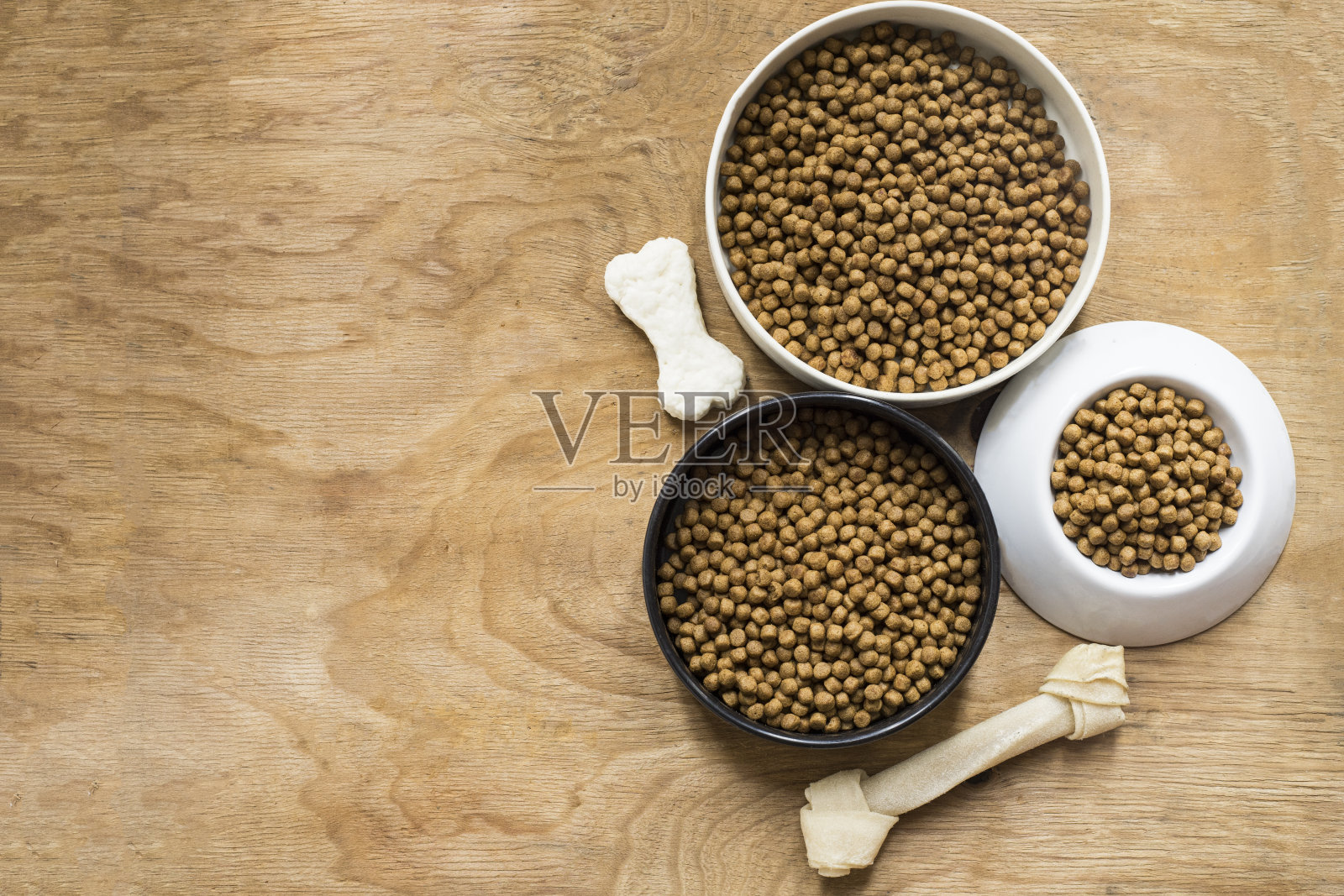 木桌上放着狗骨头和狗粮照片摄影图片