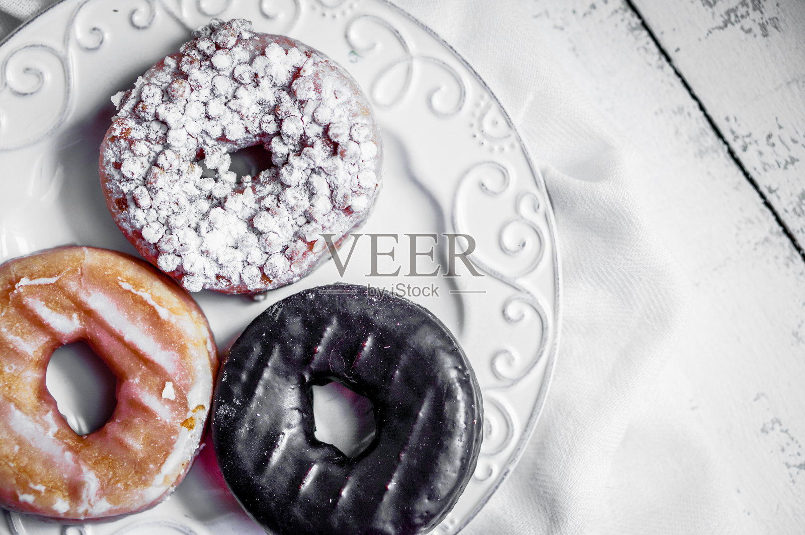 乡村木制背景上的什锦甜甜圈照片摄影图片