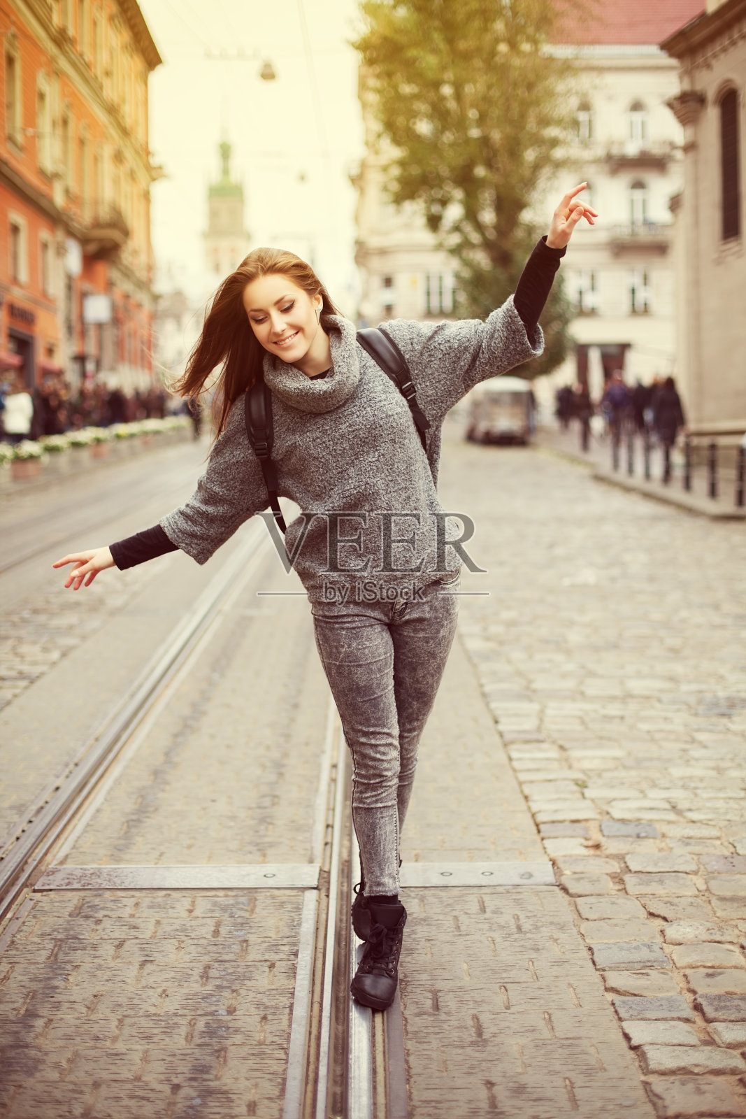 快乐的年轻微笑的女人走在铁路上照片摄影图片
