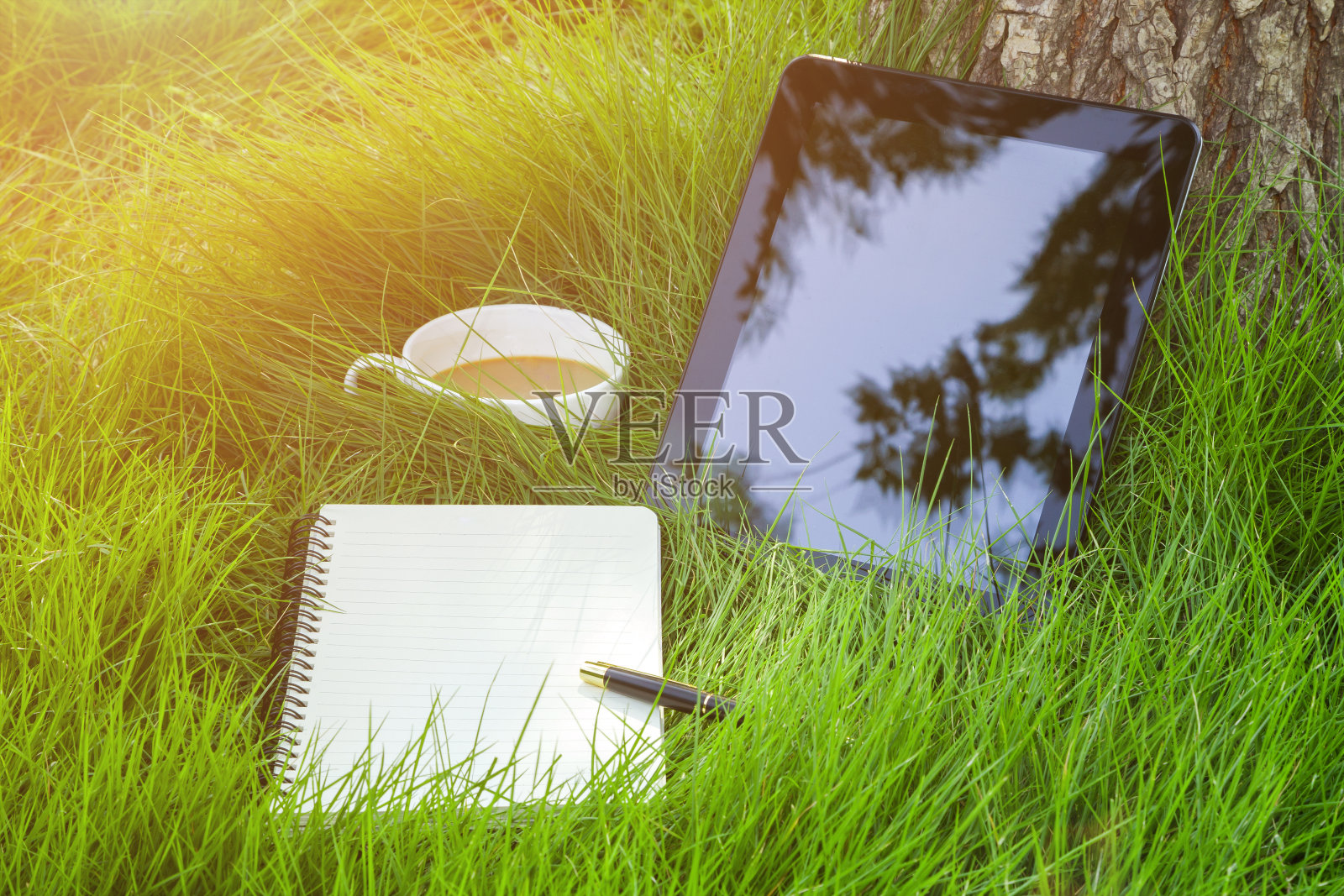 工作在自然界:数字平板电脑和咖啡在草的背景照片摄影图片