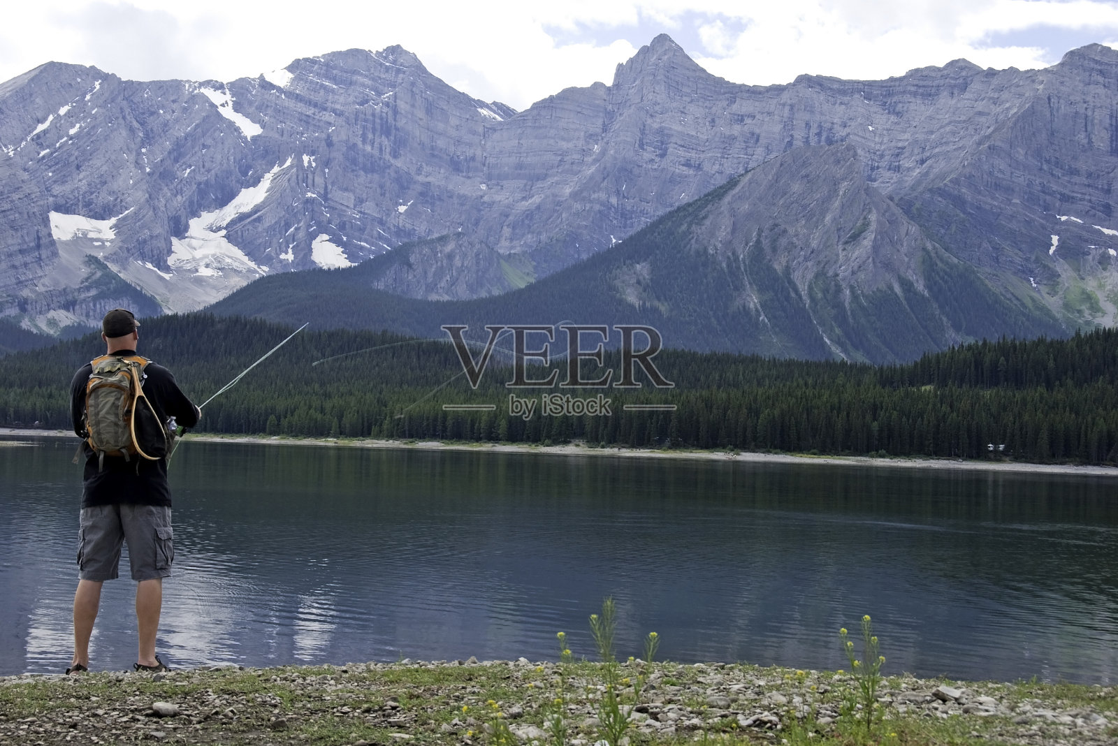 人飞在山上的湖上钓鱼照片摄影图片