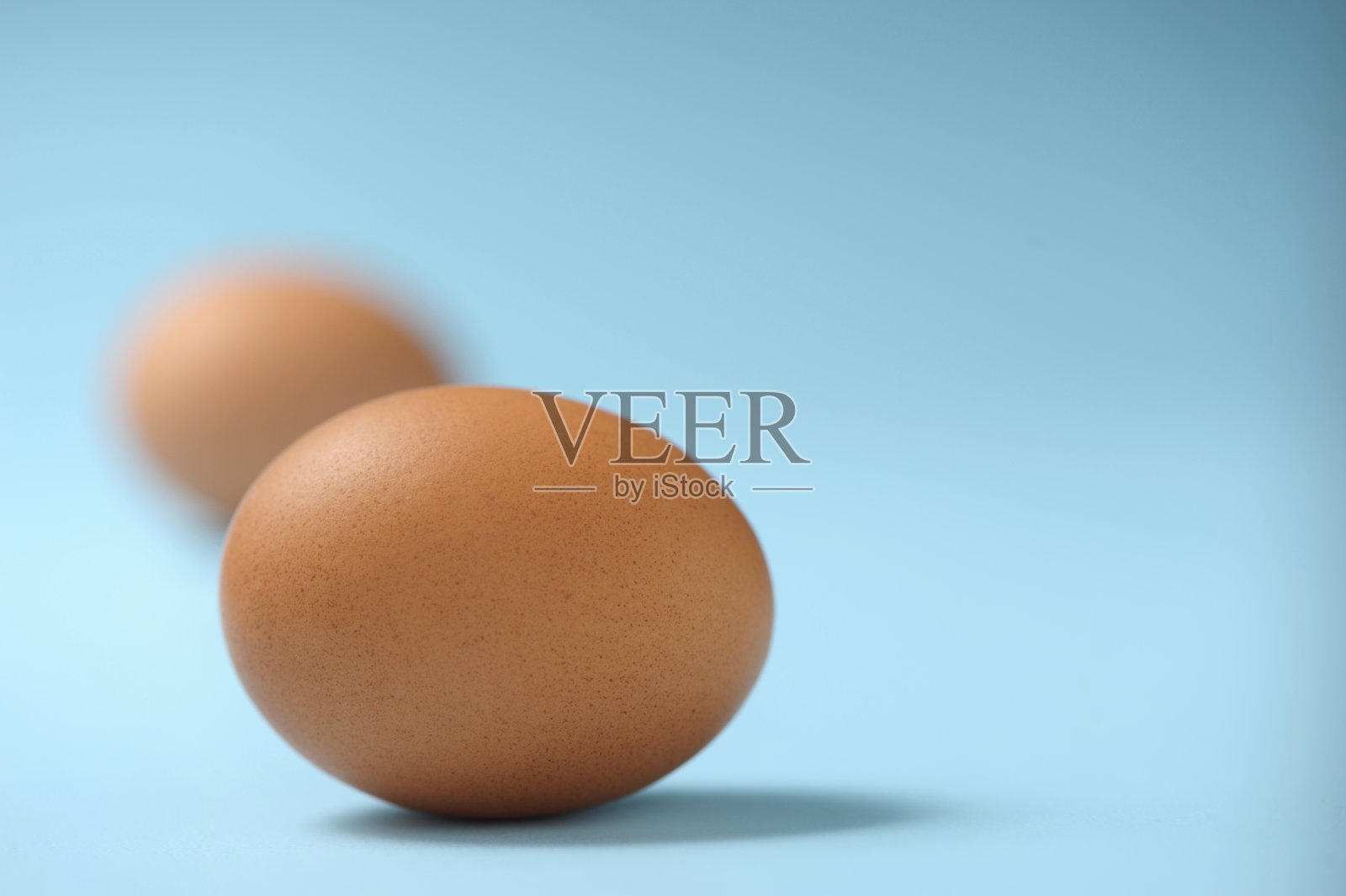 蓝色背景上的有机棕色鸡蛋的特写照片摄影图片