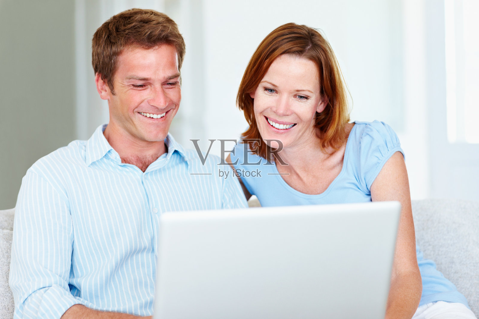 微笑的中年夫妇使用笔记本电脑照片摄影图片