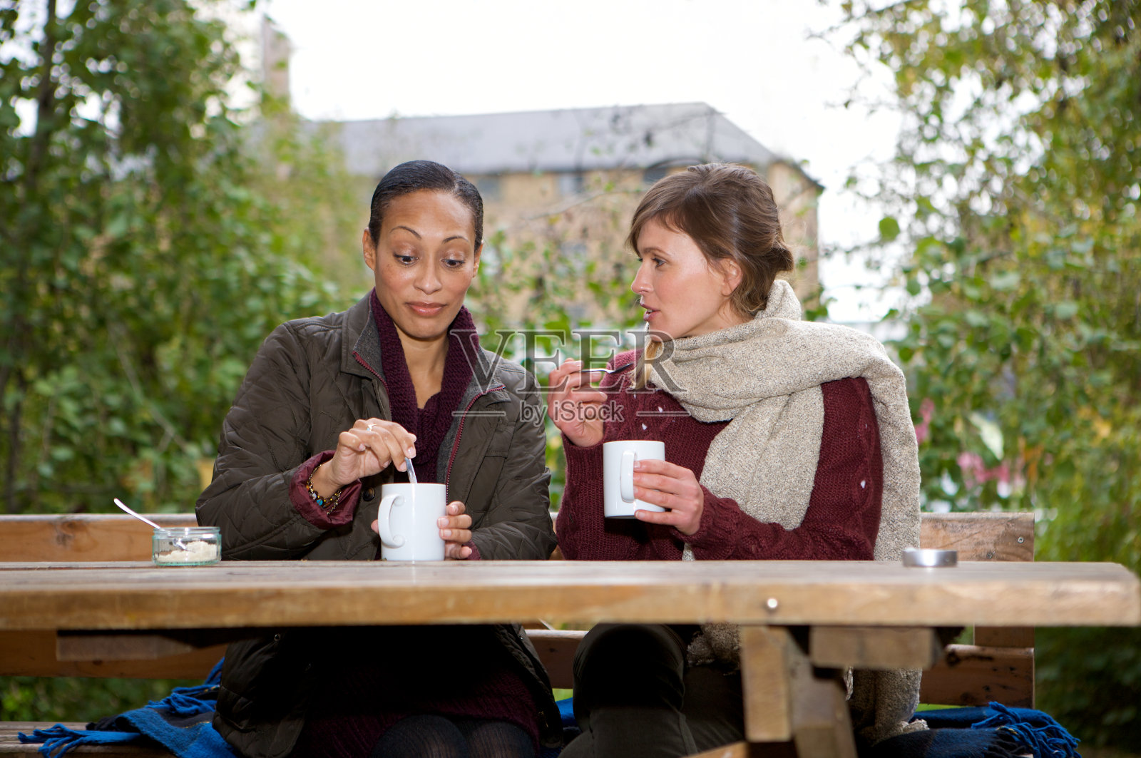 两个女性朋友边喝咖啡边聊天,其中一个听到了令人惊讶的消息照片摄影图片