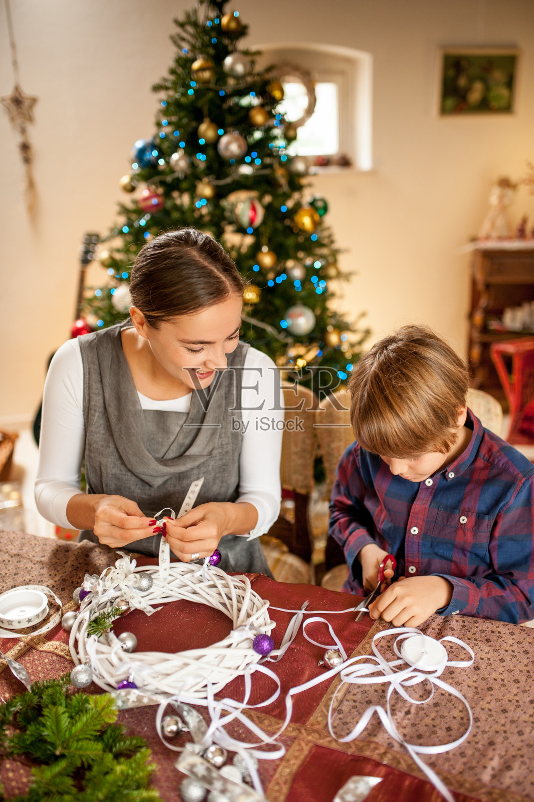 母亲和儿子正在准备圣诞花环照片摄影图片