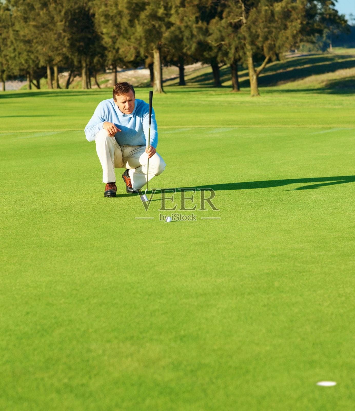 成熟的高尔夫球手正在为下一次击球瞄准照片摄影图片