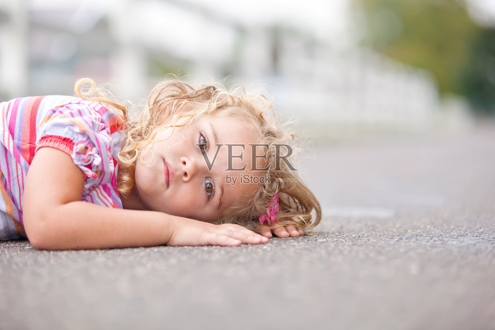 躺在柏油路的女孩照片摄影图片
