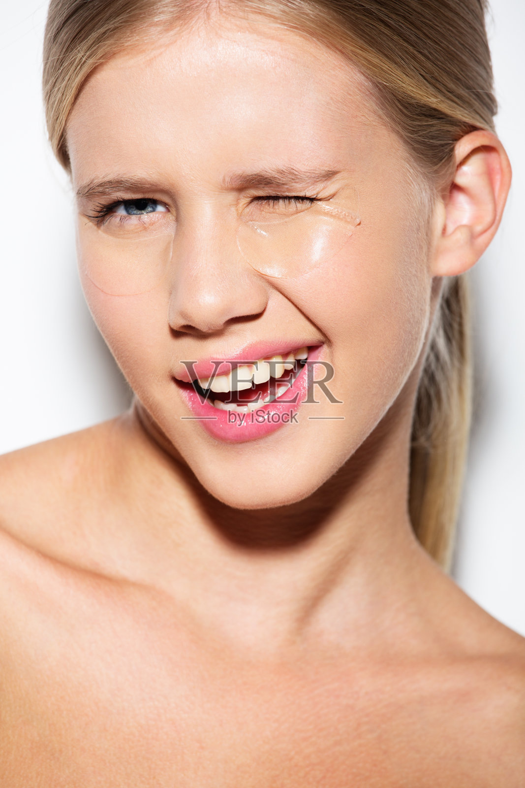 一个带着眼罩眨眼的女孩的肖像照片摄影图片