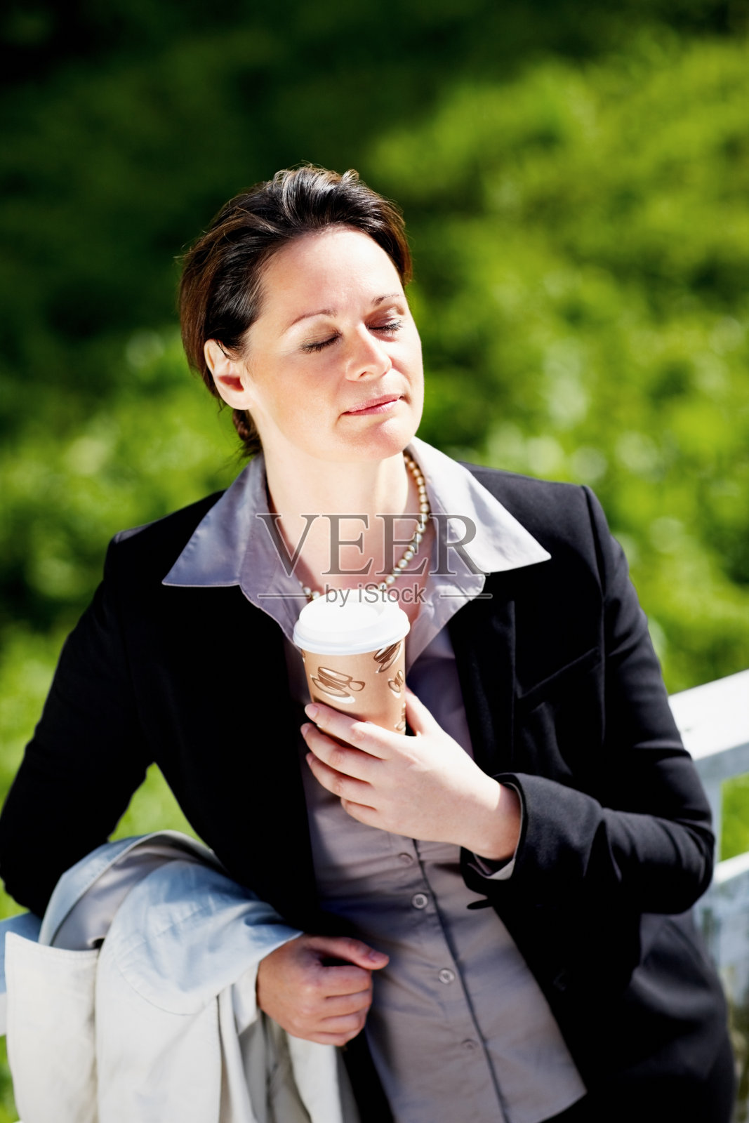 在公园里拿着一次性咖啡杯的女人照片摄影图片