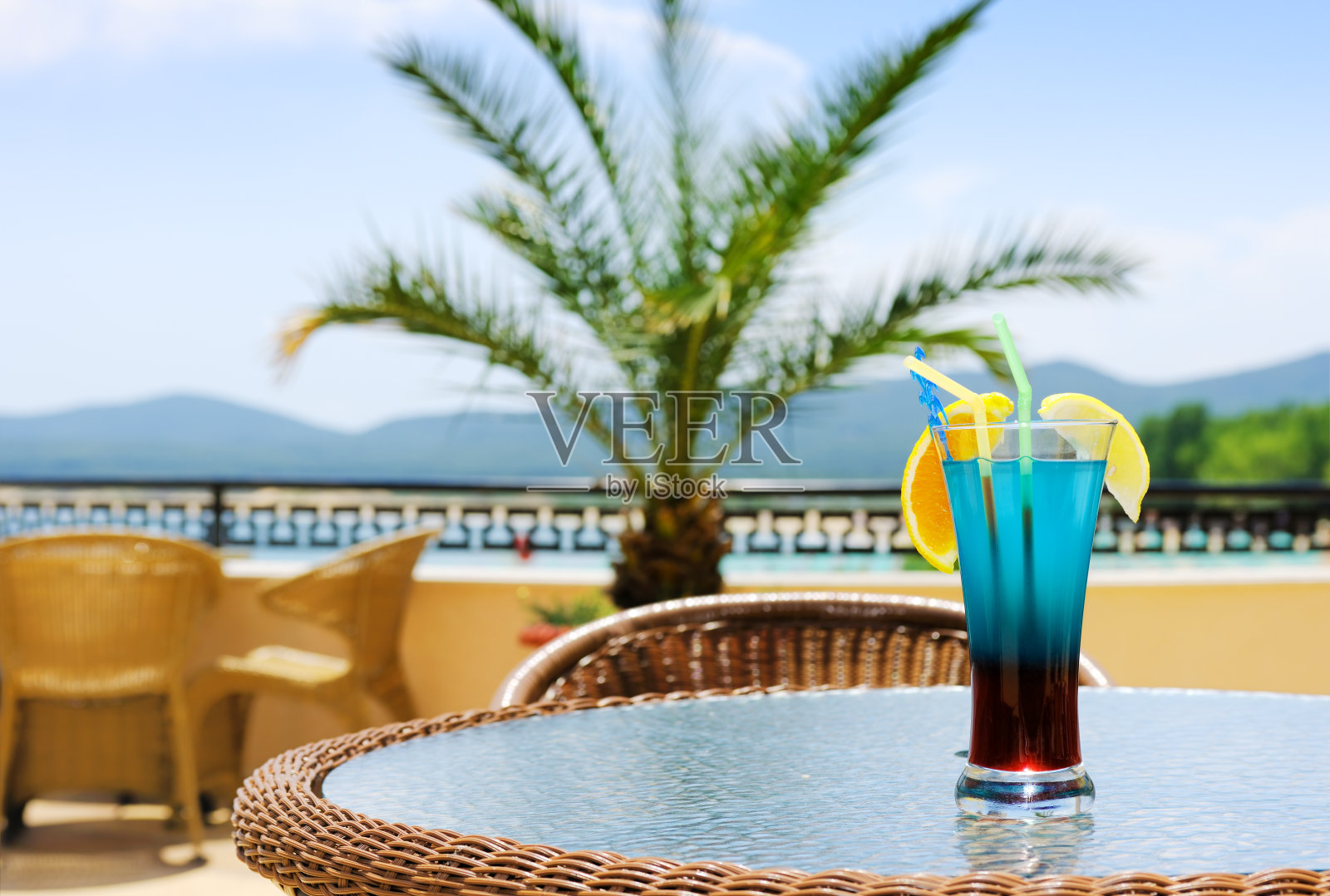 蓝色的鸡尾酒在咖啡店庭院的桌子上照片摄影图片