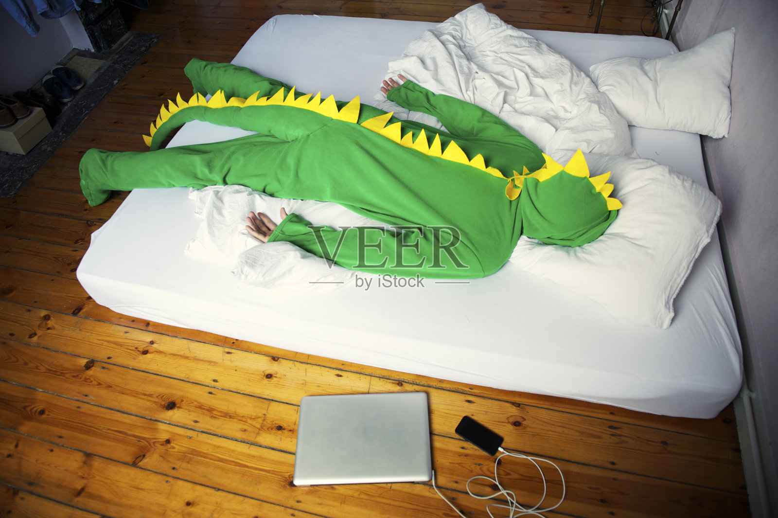 一个穿着恐龙服装的男人在深夜昏睡过去照片摄影图片