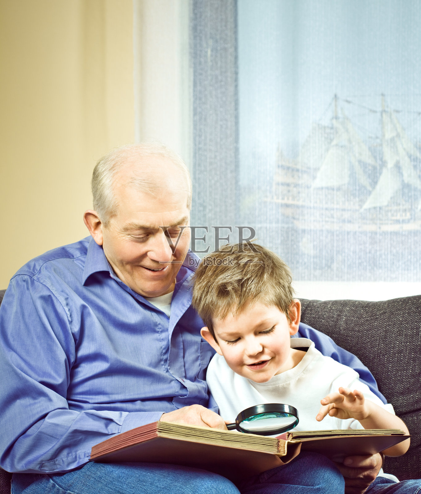 爷爷和孙子一起看邮票照片摄影图片
