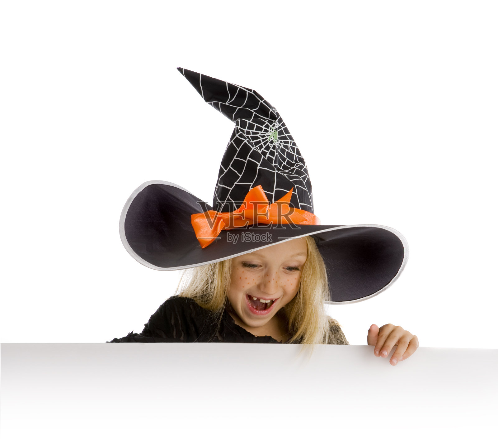 滑稽的小女巫举着一个牌子。照片摄影图片