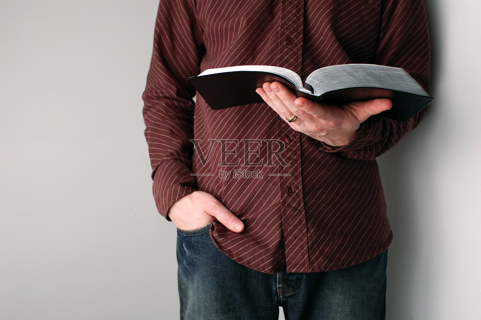 穿着随意的基督徒拿着一本打开的圣经照片摄影图片