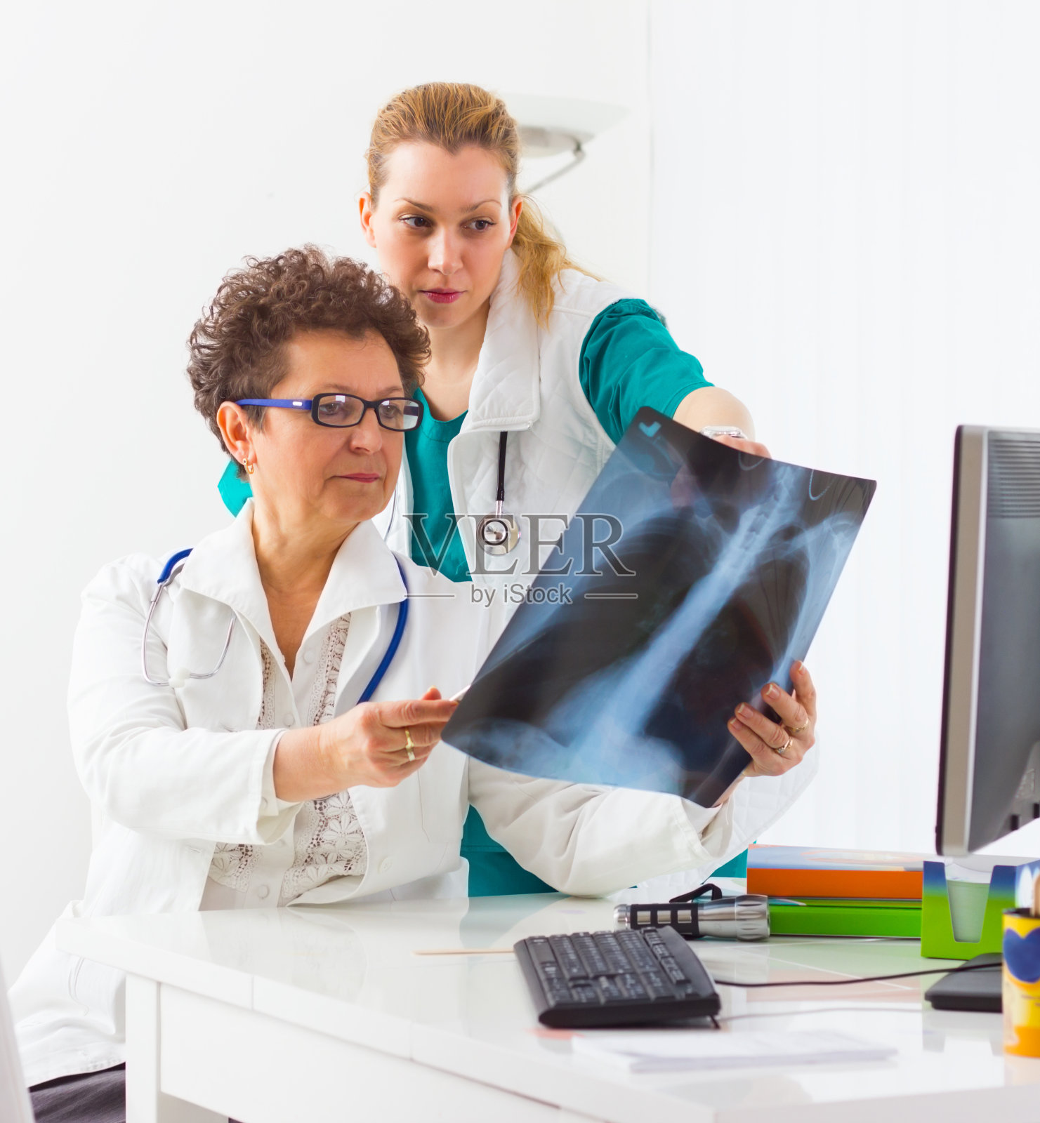 医生在看x光片。照片摄影图片