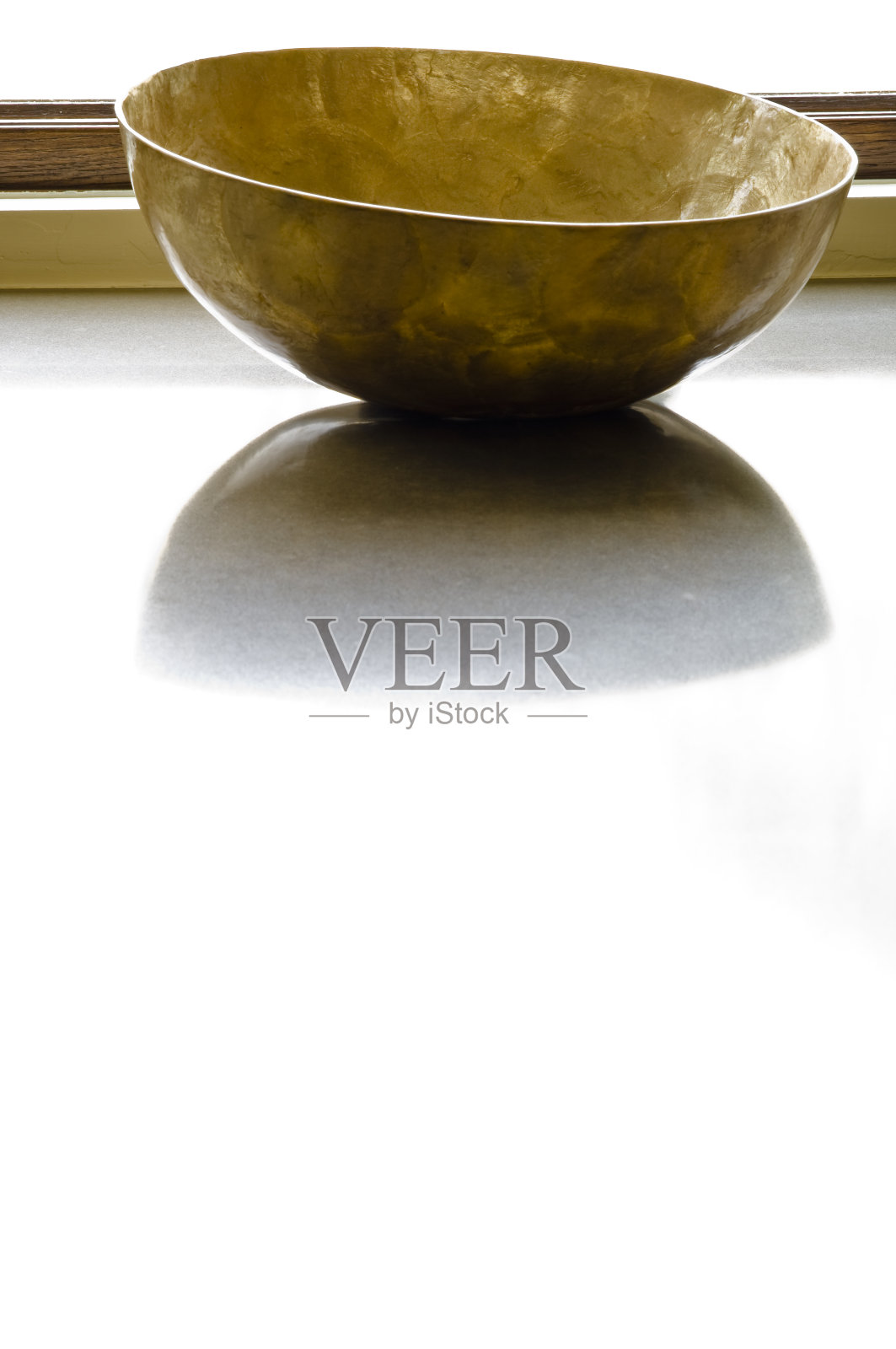 在柜台上有反射和窗户光线的端菜碗照片摄影图片