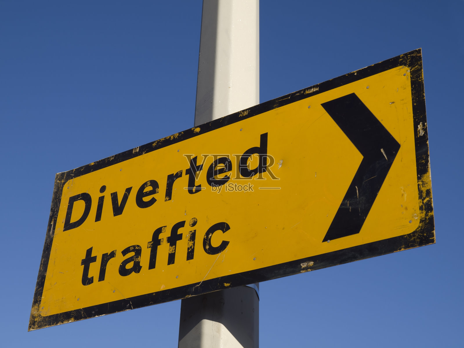 灯柱上的黄色转道交通标志照片摄影图片