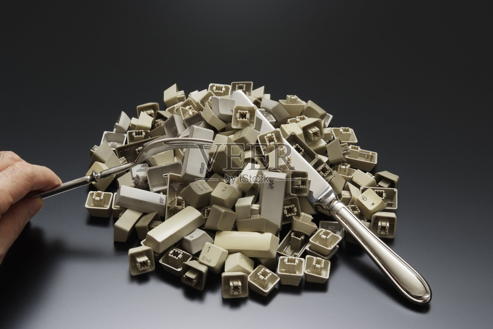 办公桌上带有银器的叠放电脑键盘按键照片摄影图片