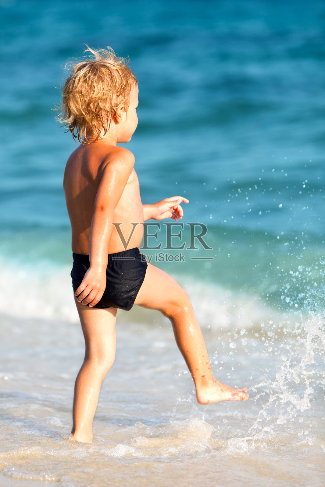 小孩子在海边玩耍照片摄影图片