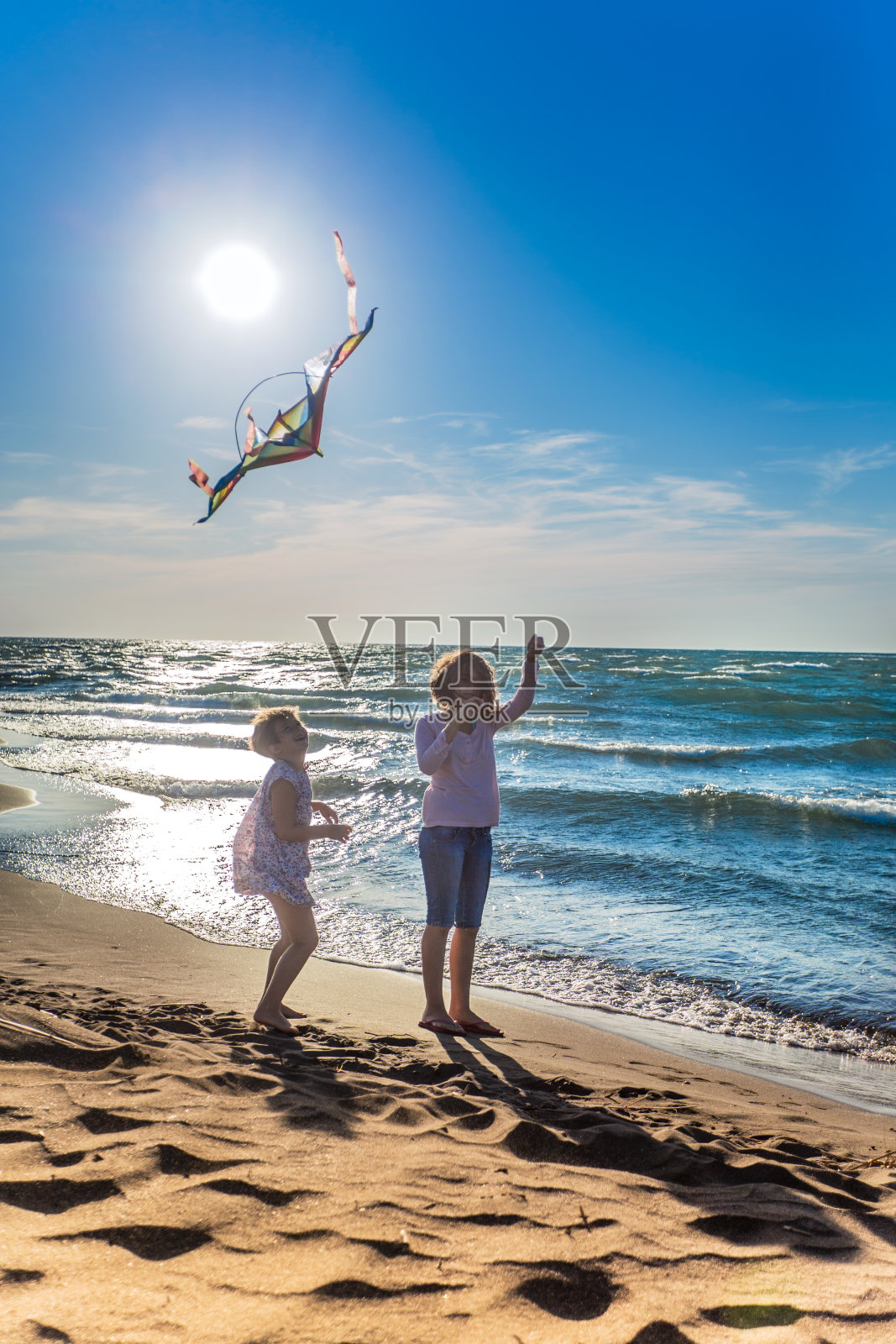 可爱的女孩在海滩上放风筝照片摄影图片