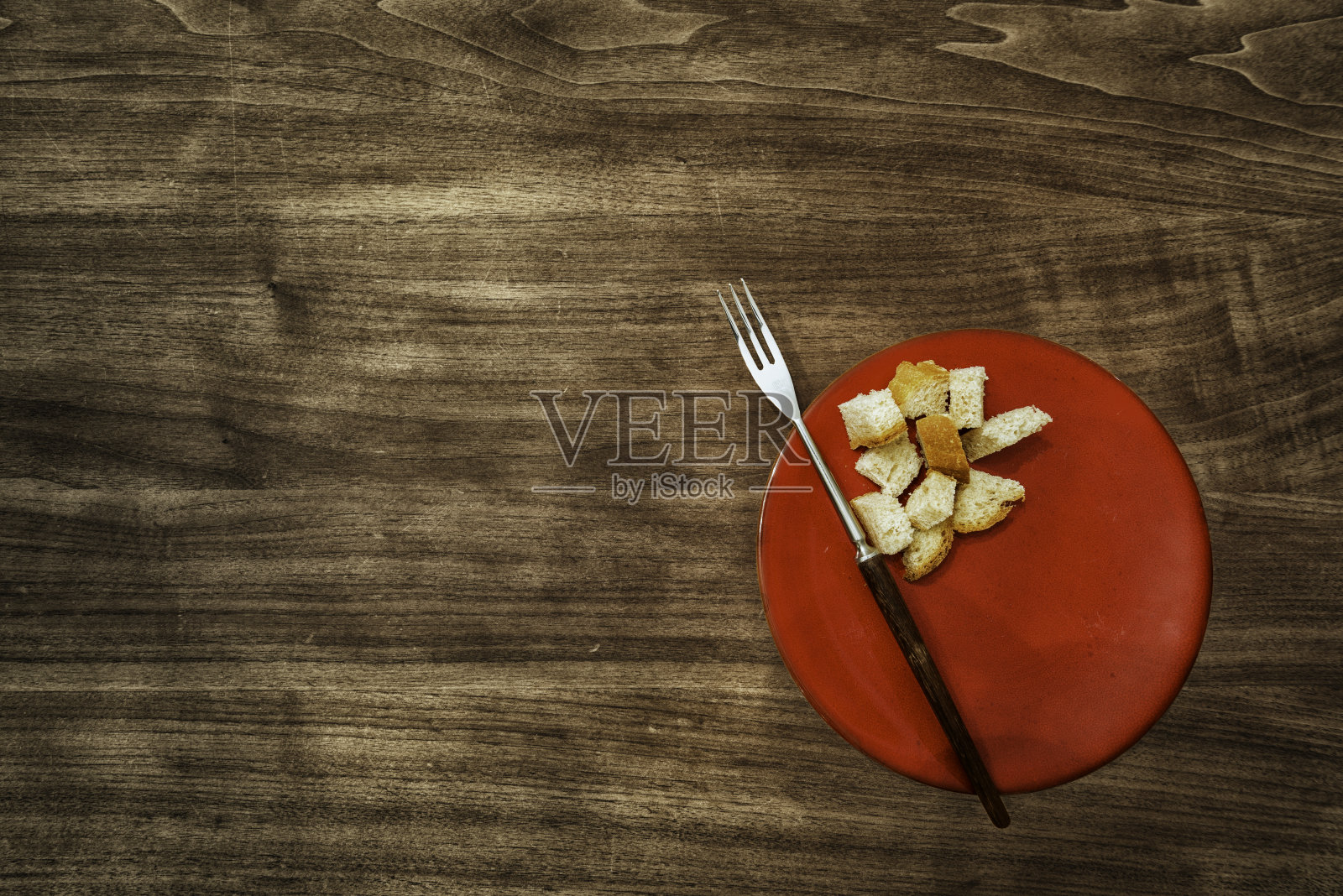 典型的红色火锅盘和叉子放在胡桃木桌上照片摄影图片