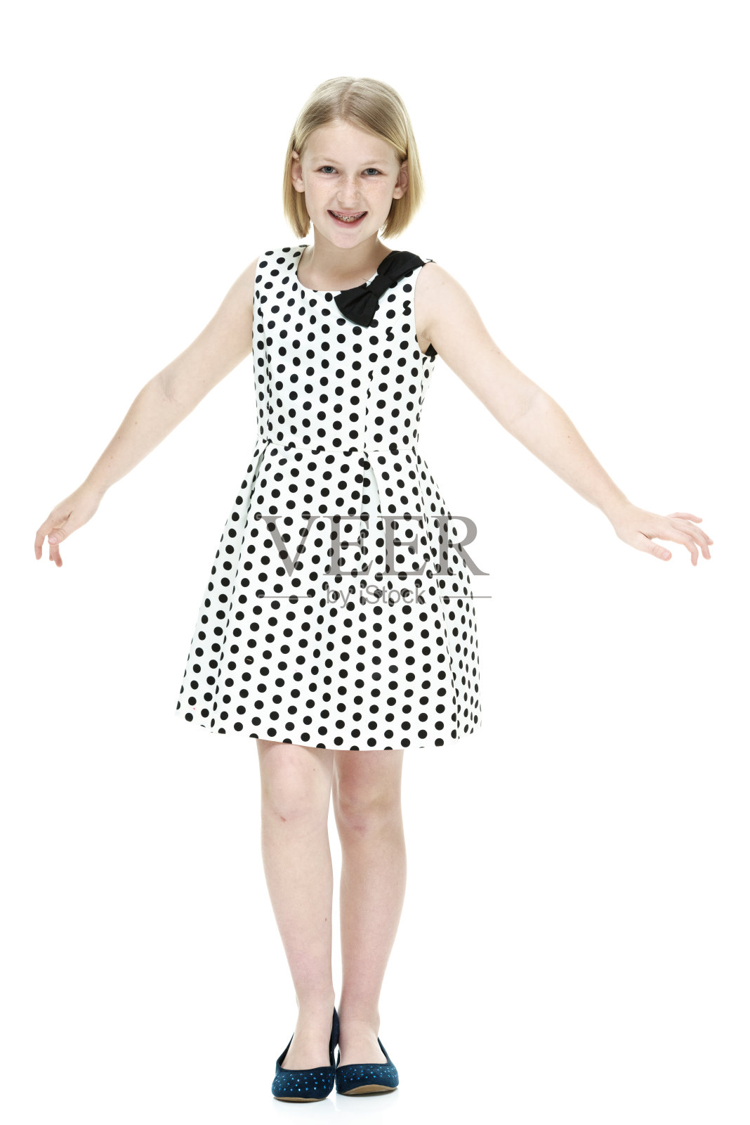 小女孩微笑着站在那里看着摄像机照片摄影图片