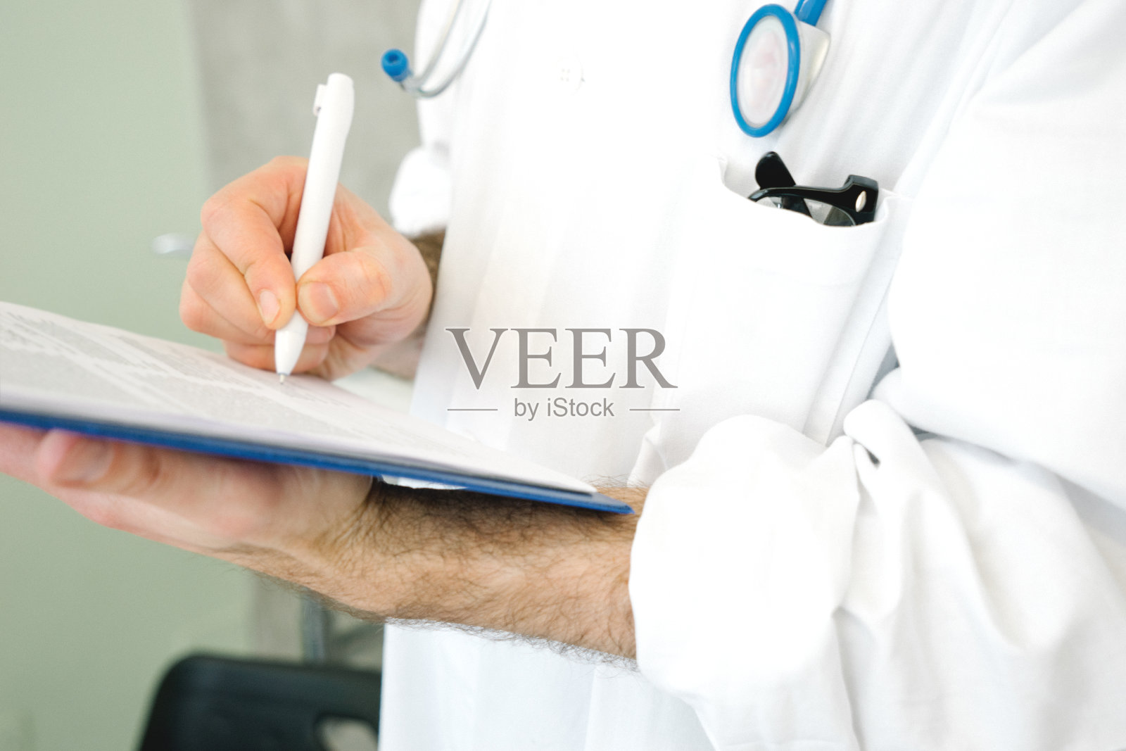 写医疗报告的男医生照片摄影图片