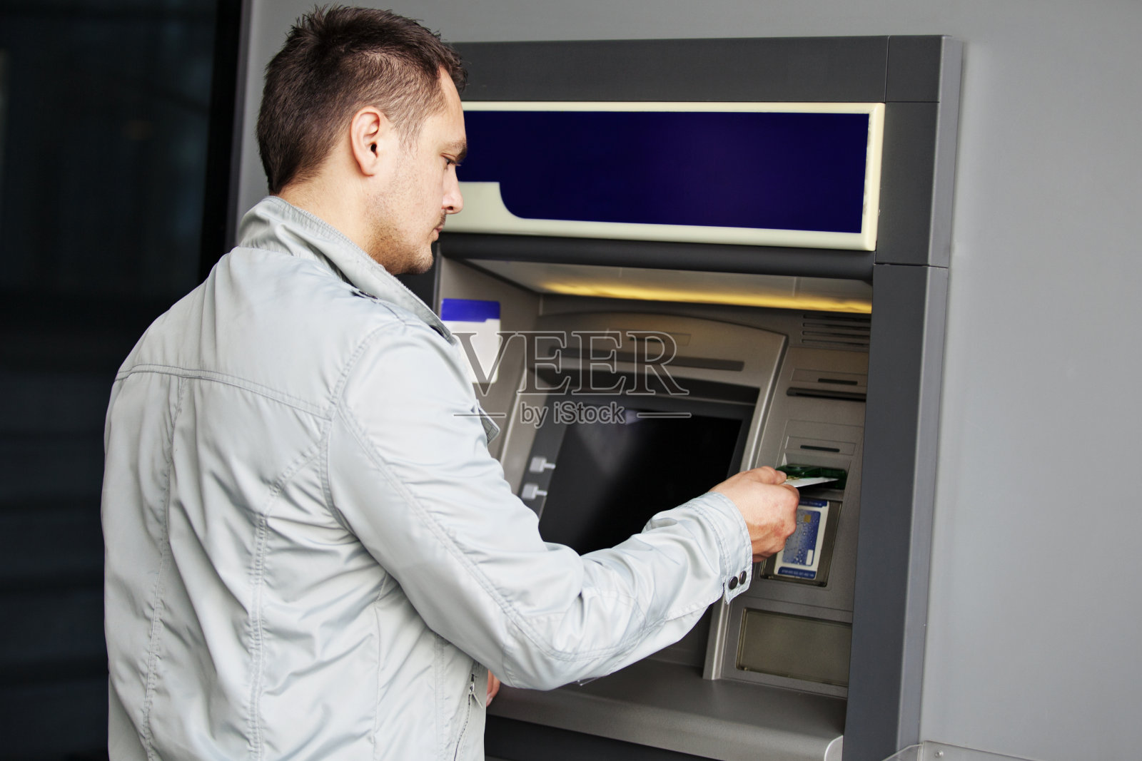 在自动取款机上取款的人照片摄影图片