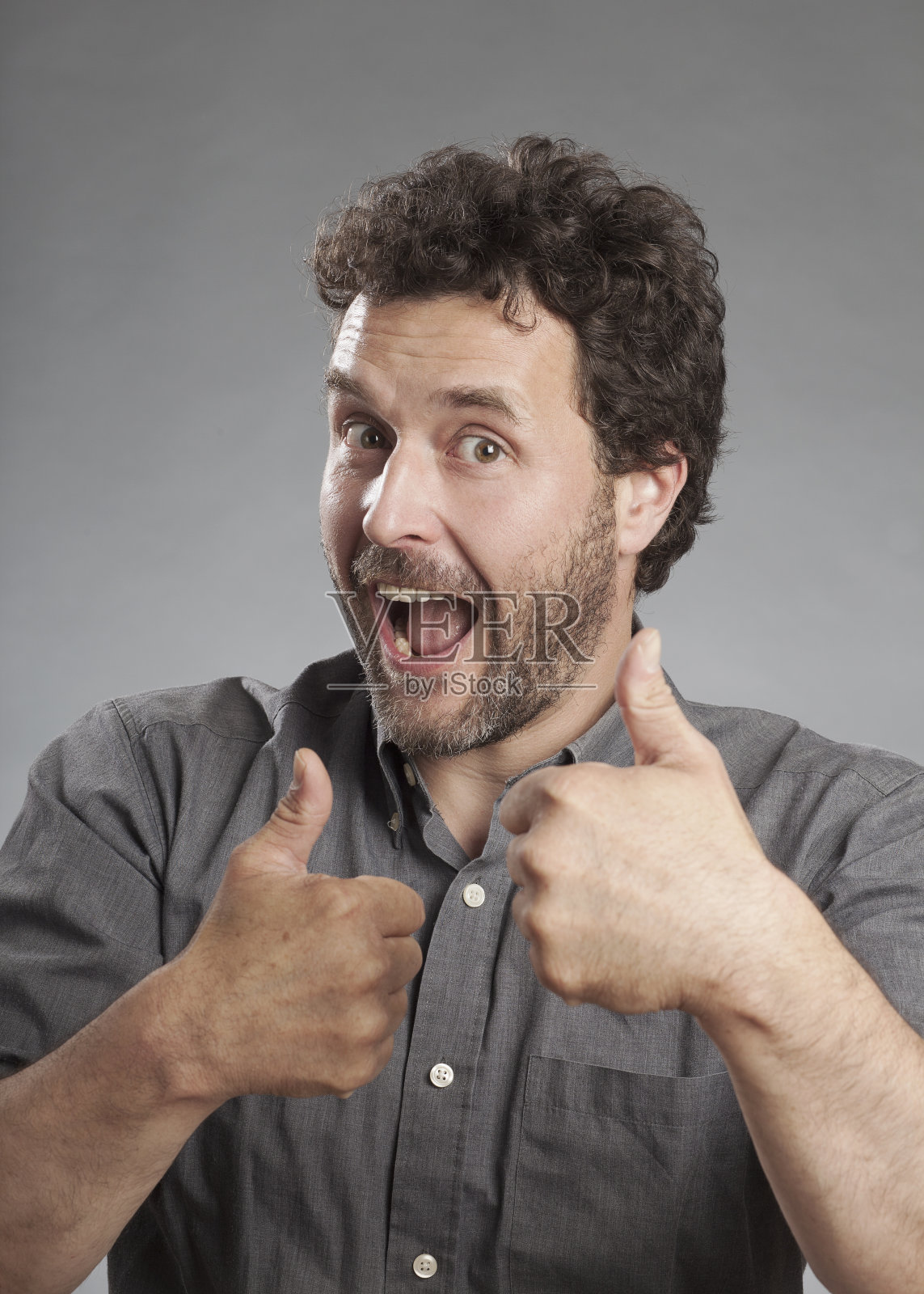 穿灰色衬衫的男人翘着大拇指照片摄影图片